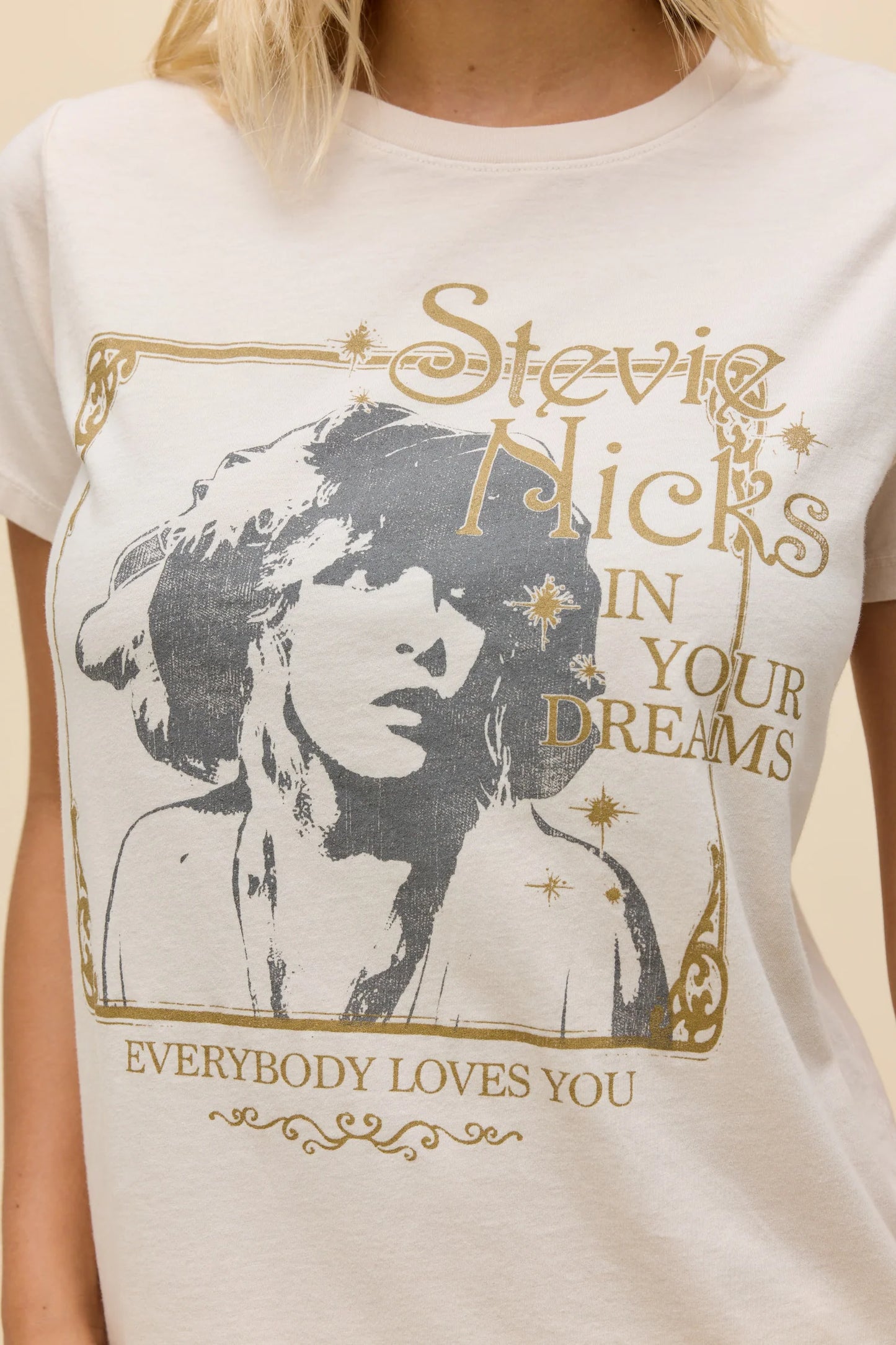 Dirty white tee closeup with Stevie Nicks portrait graphic and gold slogan text