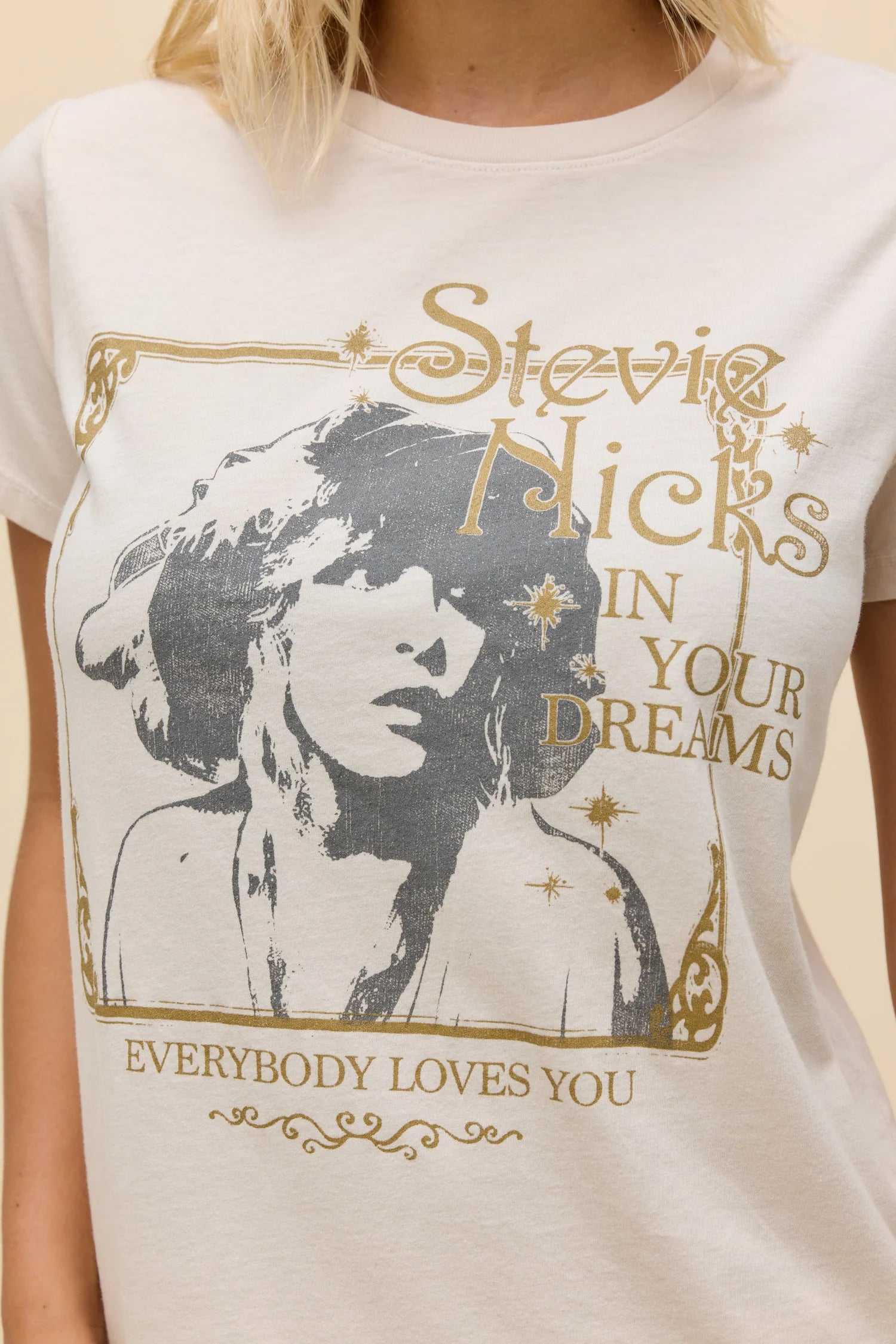 Dirty white tee closeup with Stevie Nicks portrait graphic and gold slogan text
