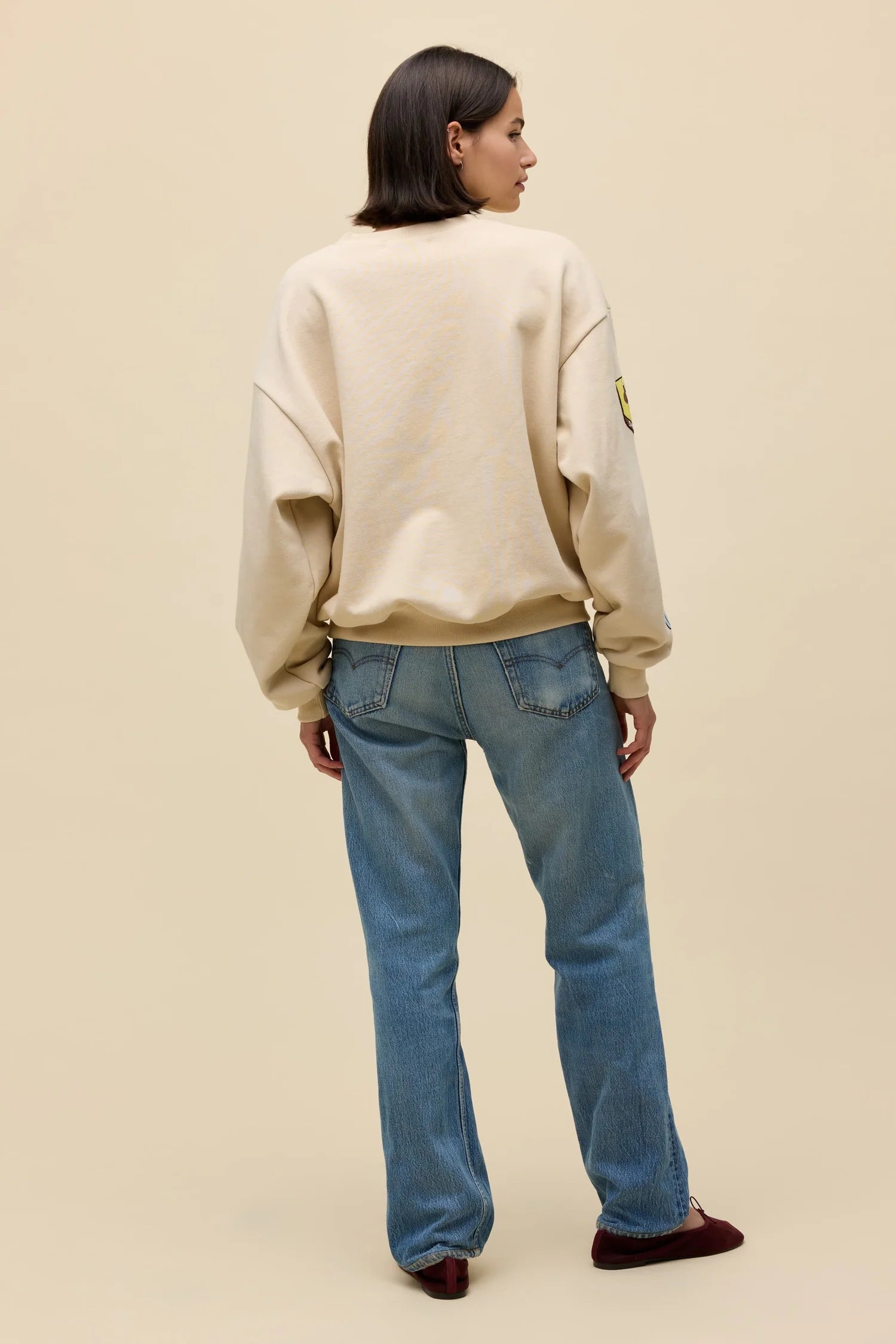 Sand oversized crew sweatshirt back view with small western patch on sleeve