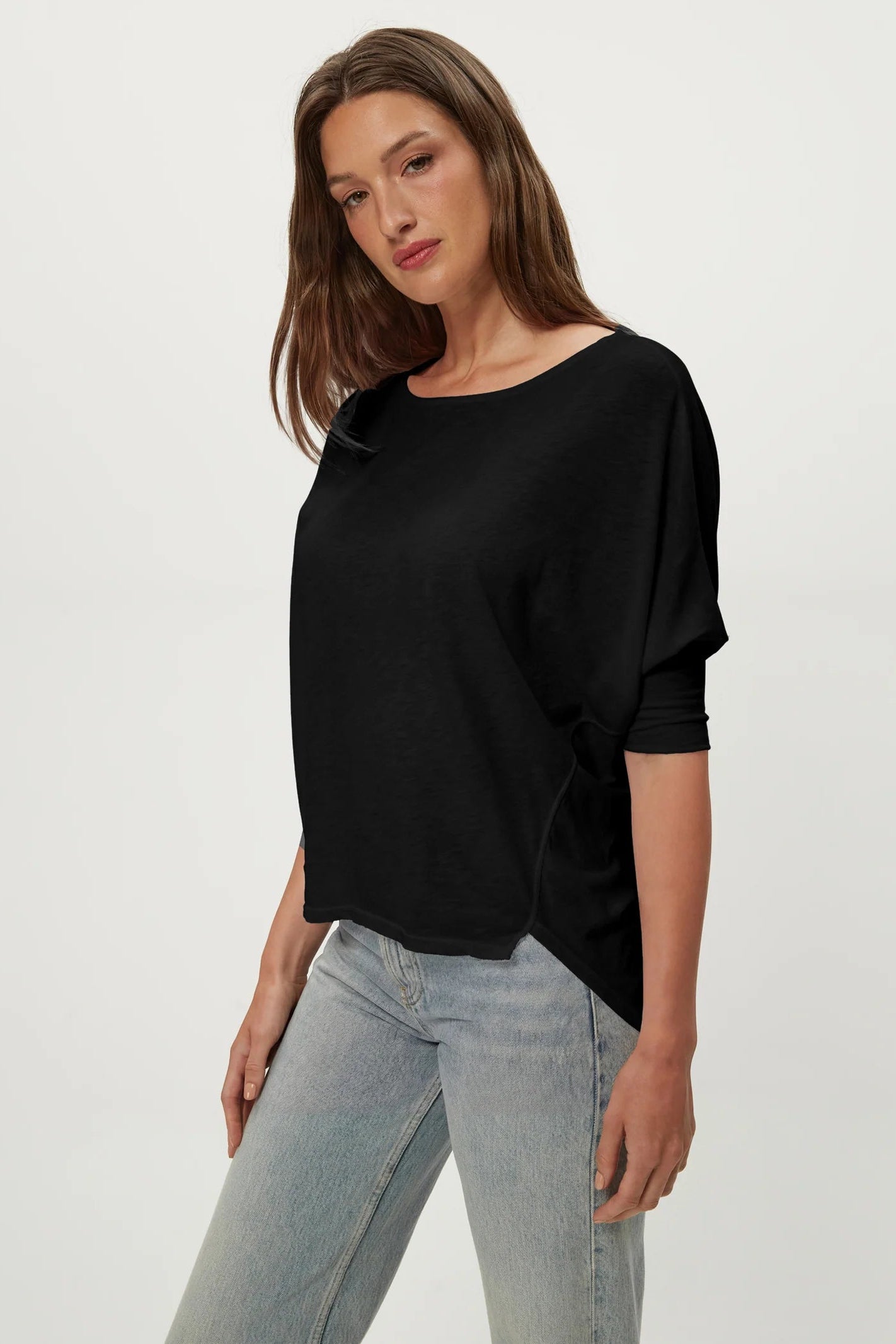 Black dolman tee with crew neck and draped short sleeves, side view