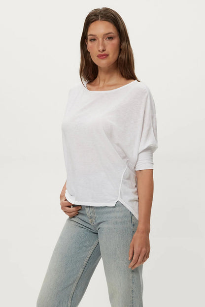 White dolman tee with crew neck and draped short sleeves, side view