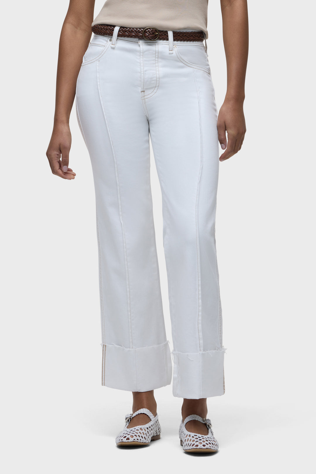 White wide-leg jeans close-up: front pockets, belt loops, and stitched seams