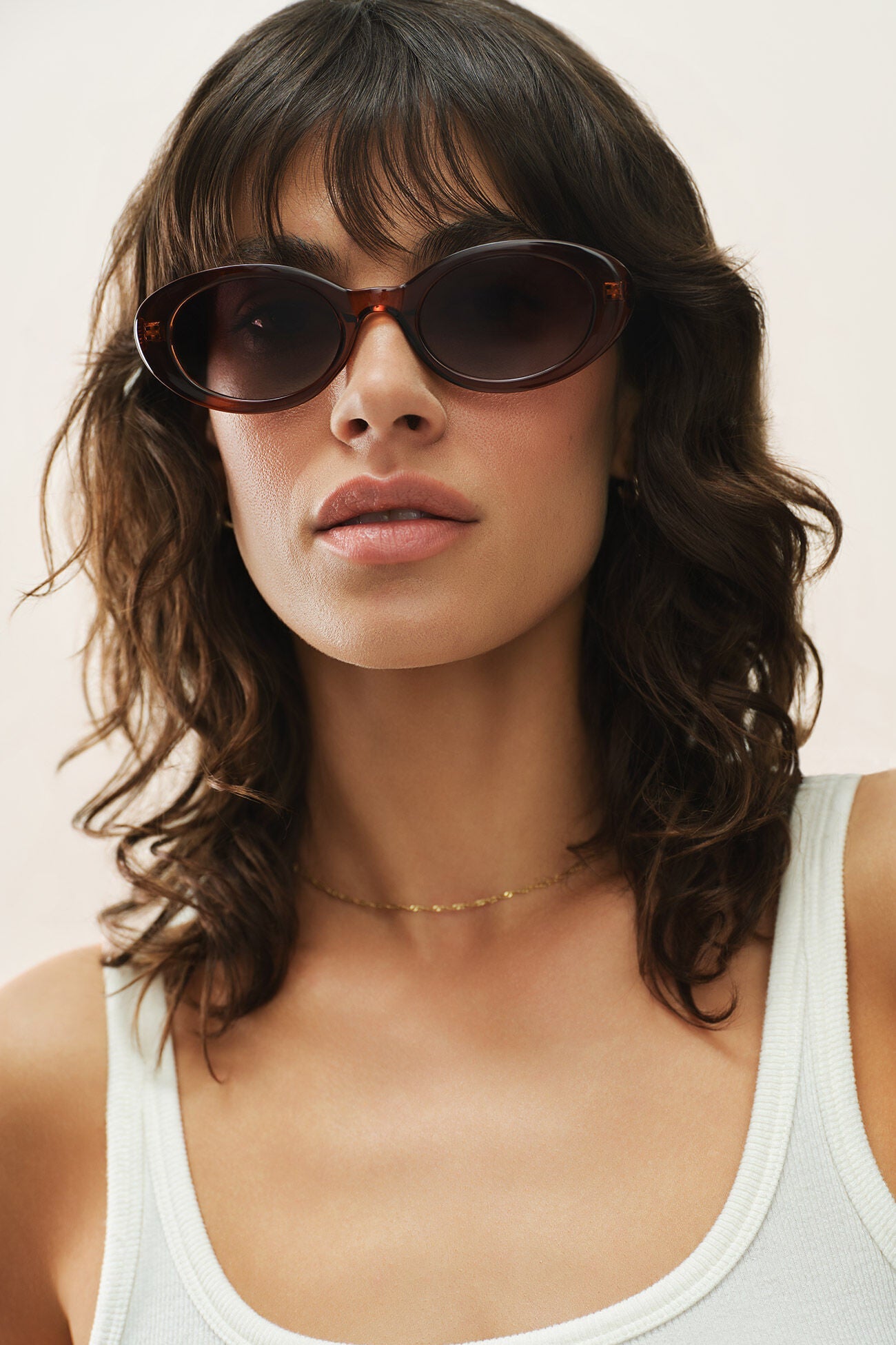 Brown tortoiseshell oval sunglasses with dark lenses