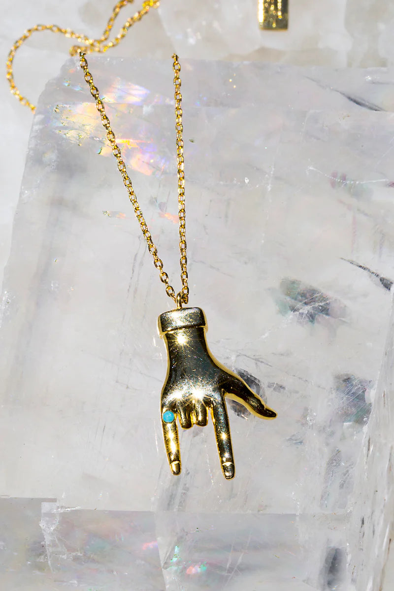 Gold hand charm necklace with small turquoise-colored gem details