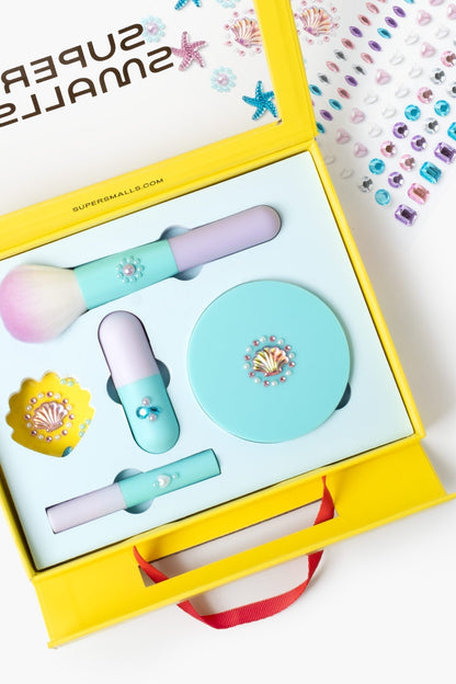 Mermaid makeup play kit, open yellow case with brushes, lip color, and compact