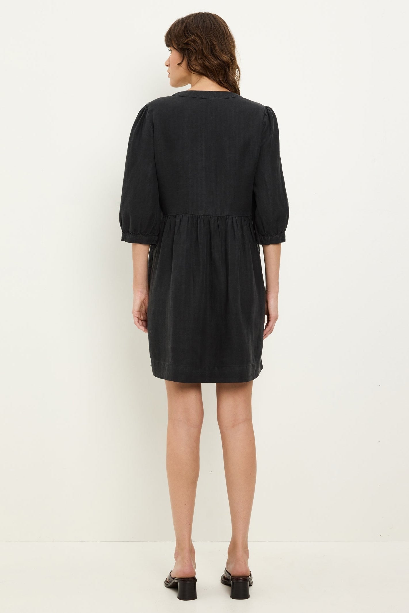 Black back-view mini dress with gathered yoke, 3/4 puff sleeves, and elastic waist