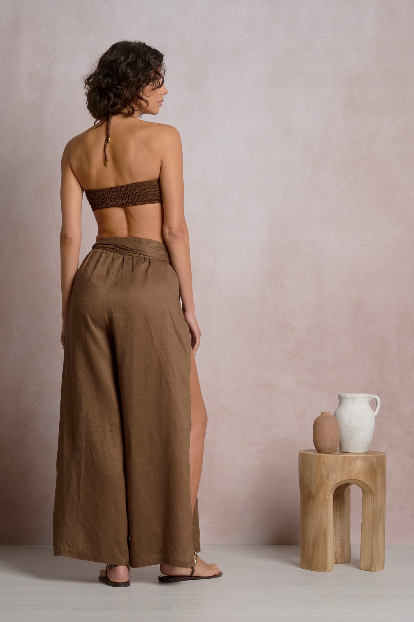 Back view of brown slit side pant with wide leg and drawstring waist.