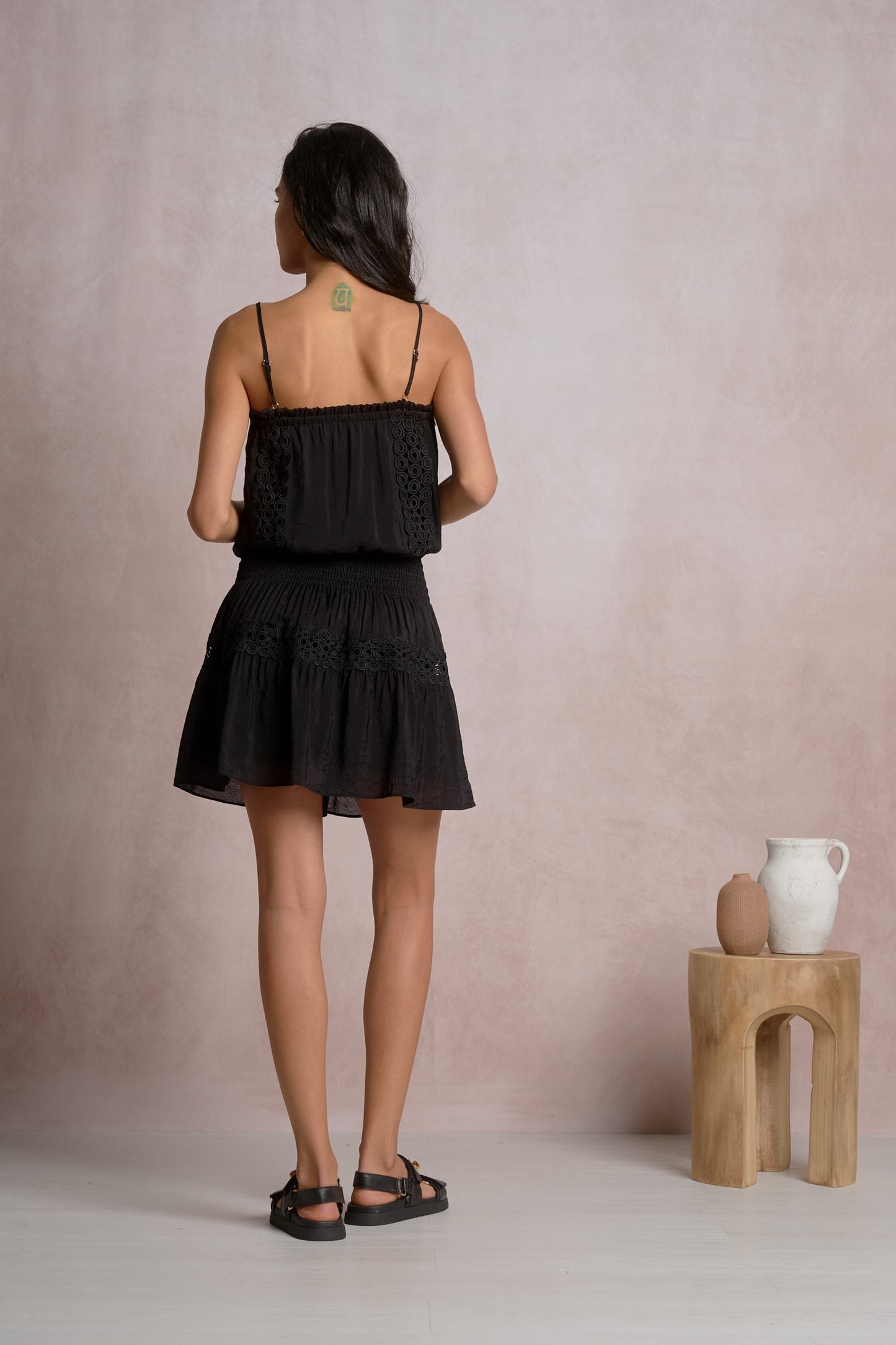 Black spaghetti strap smocked mini dress, back view with tiered ruffles