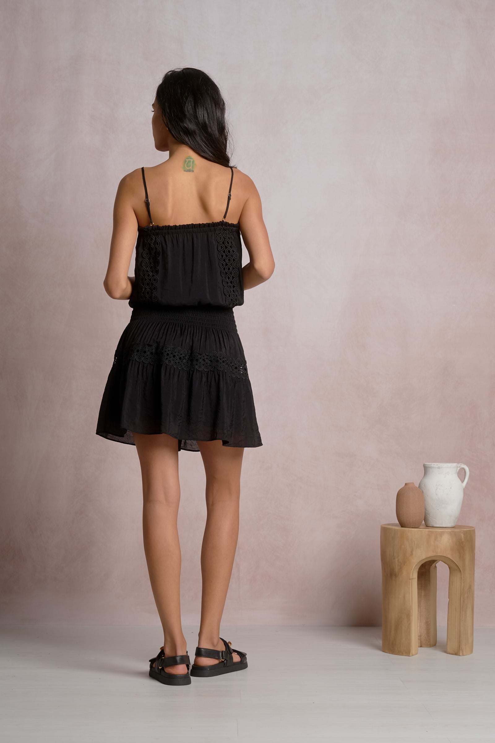 Black spaghetti strap smocked mini dress, back view with tiered ruffles