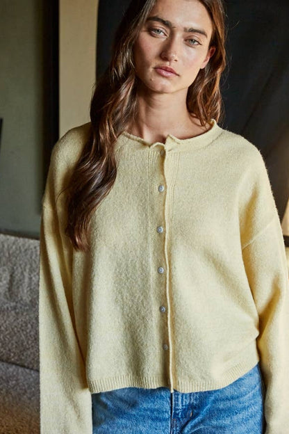 Butter-yellow knit cardigan top with crew neck and button-front; long sleeves