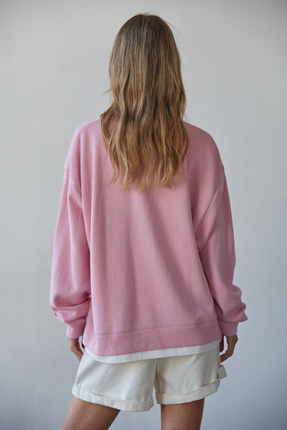 Back view: candy pink crewneck pullover with layered hem and relaxed cuffs