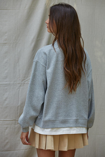 Back view: heather grey crewneck pullover with layered hem and wide sleeves