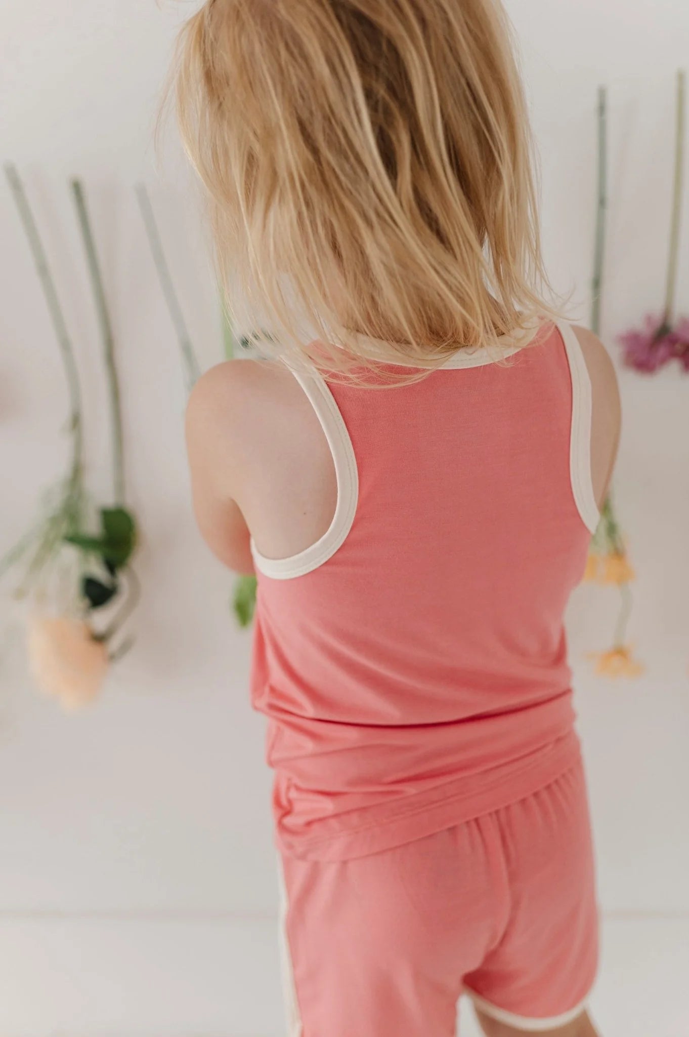 Coral pink kids track set, back view of sleeveless tank and shorts.