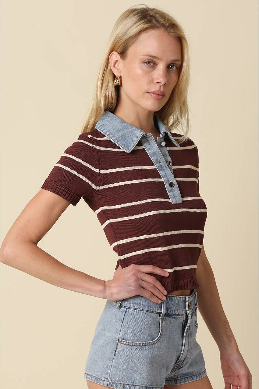 Woman wearing a brown and light taupe striped knit polo crop top with denim collar and buttons shown from the side with denim shorts 