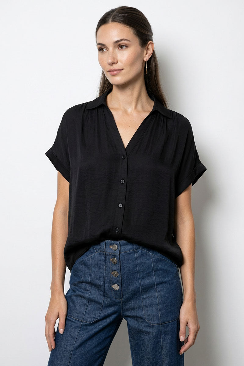 Woman wearing a black blouse and blue jeans against a white background
