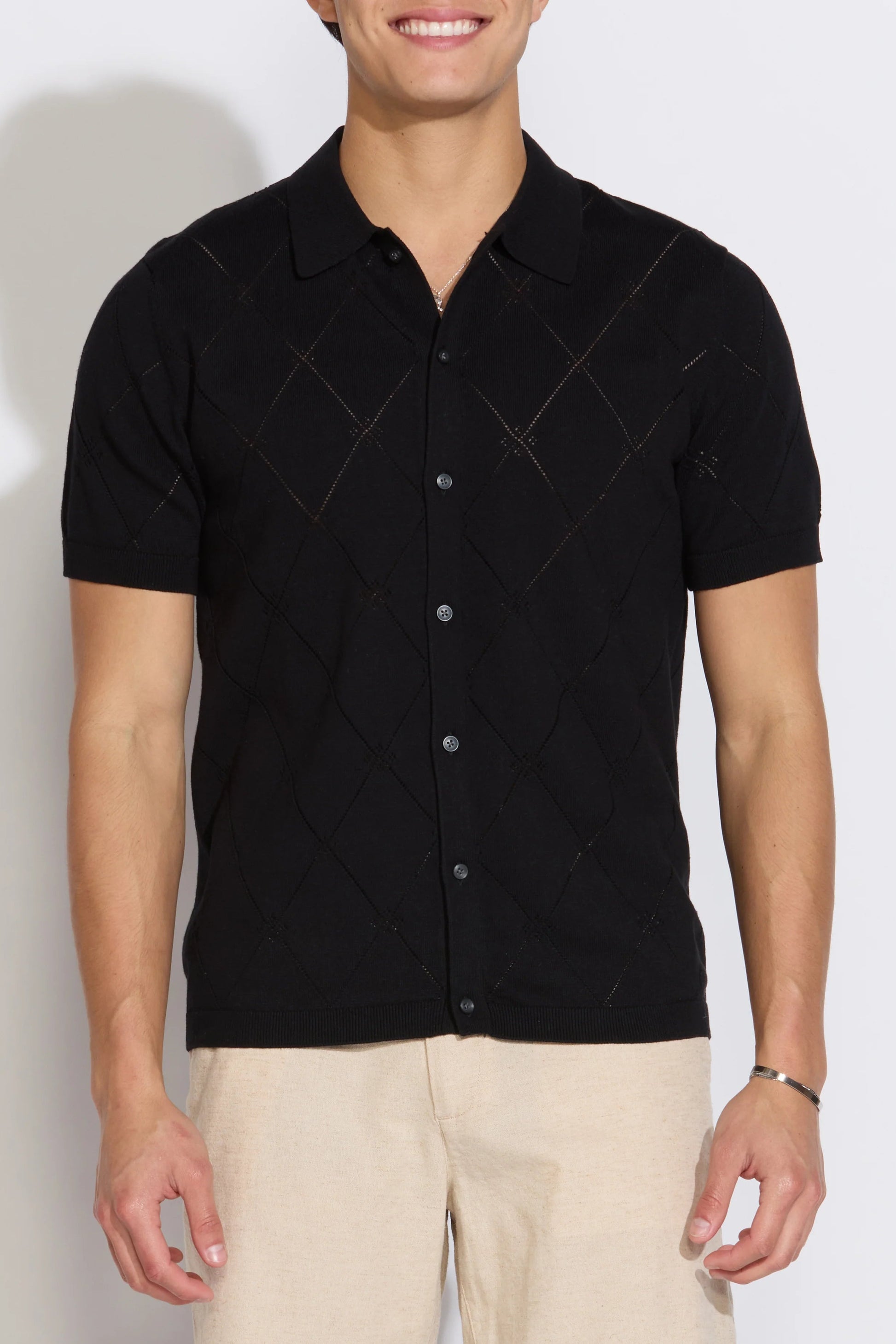 Black argyle short-sleeve sweater polo with button placket and ribbed collar