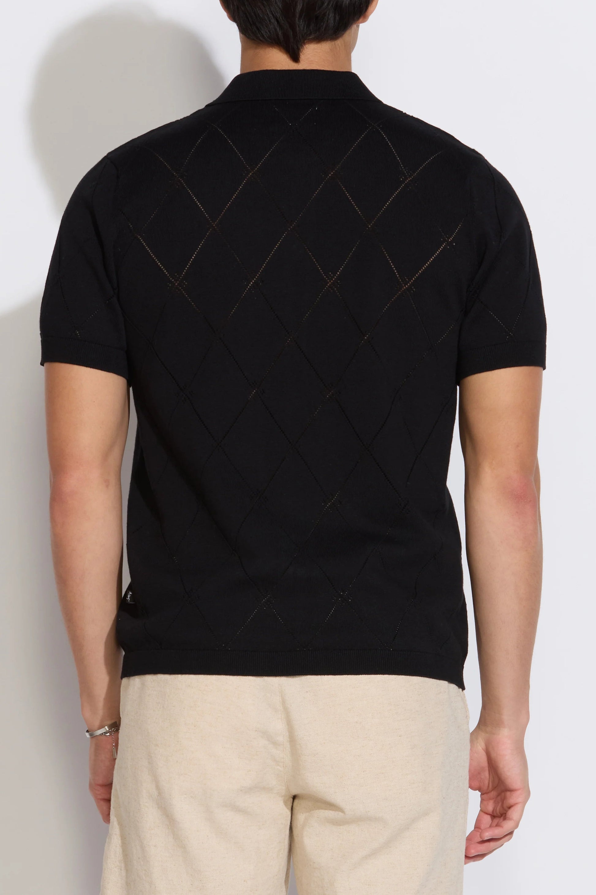 Black argyle short-sleeve sweater polo, back view with diamond pattern