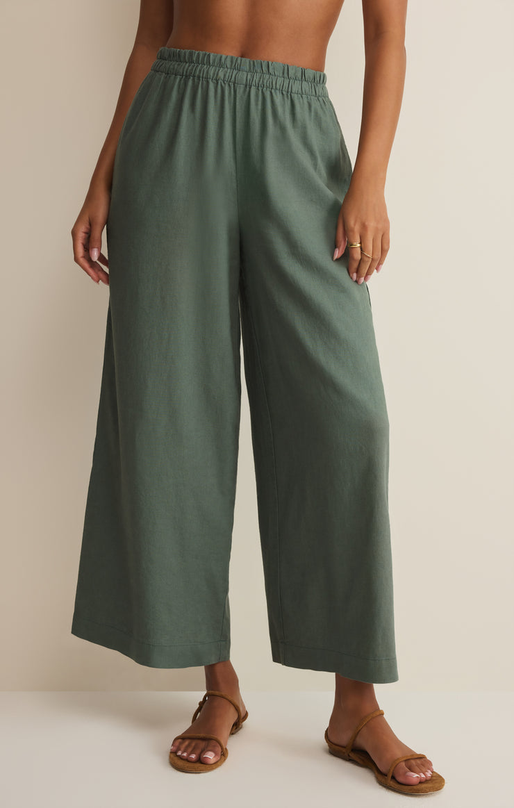 Person wearing green wide-leg linen pants on a plain background