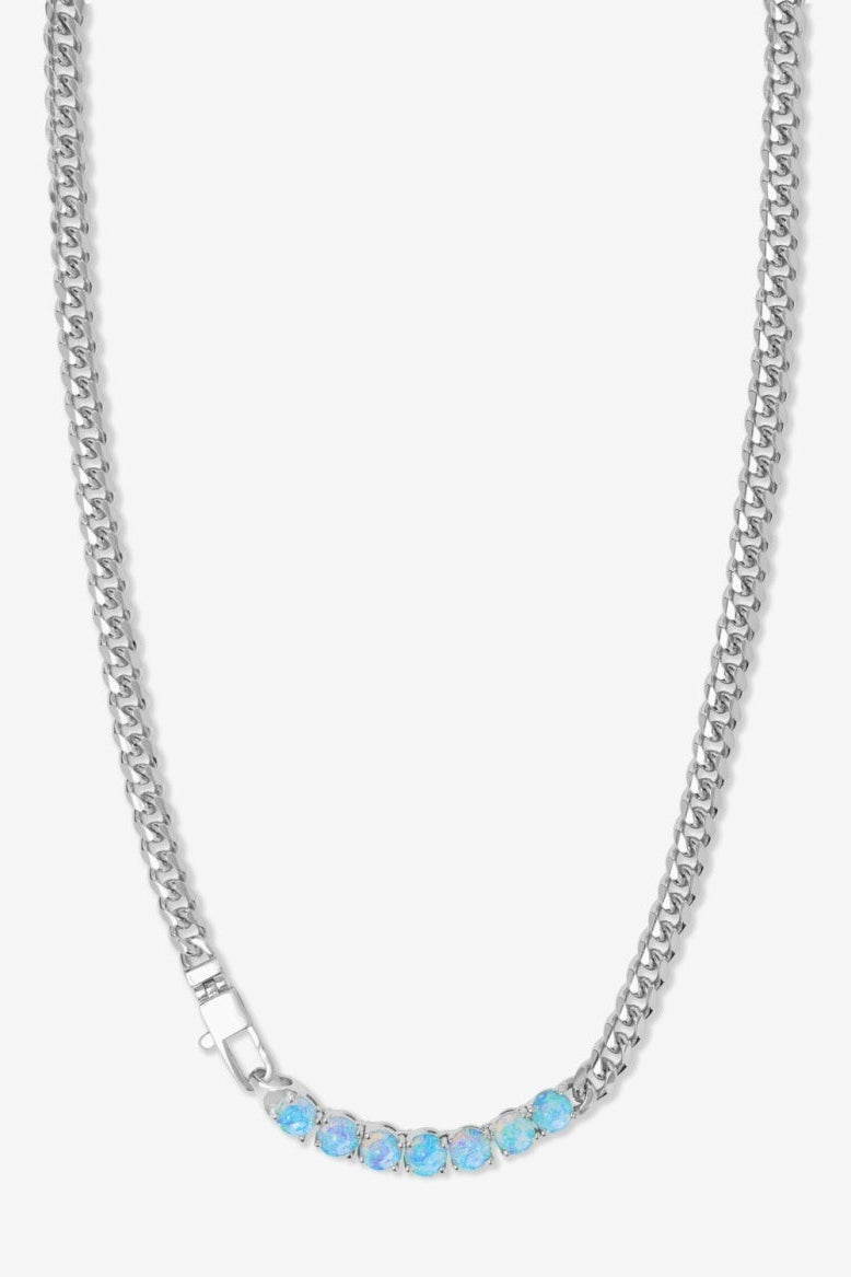 Silver chain necklace with blue stones on a white background