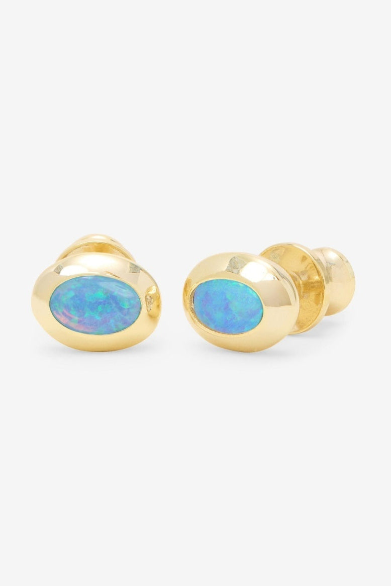 Pair of gold earrings with blue opal stones on a white background