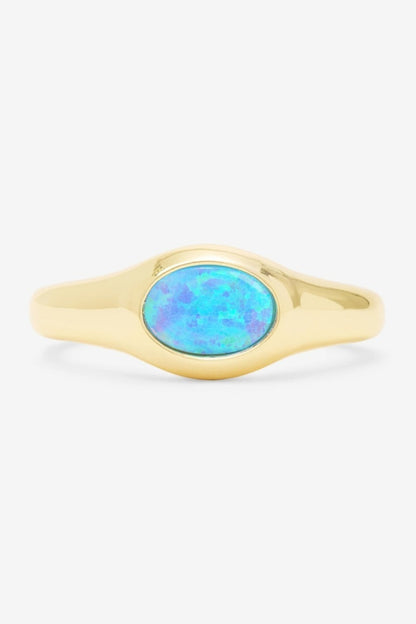 Gold and opal ring on a white background