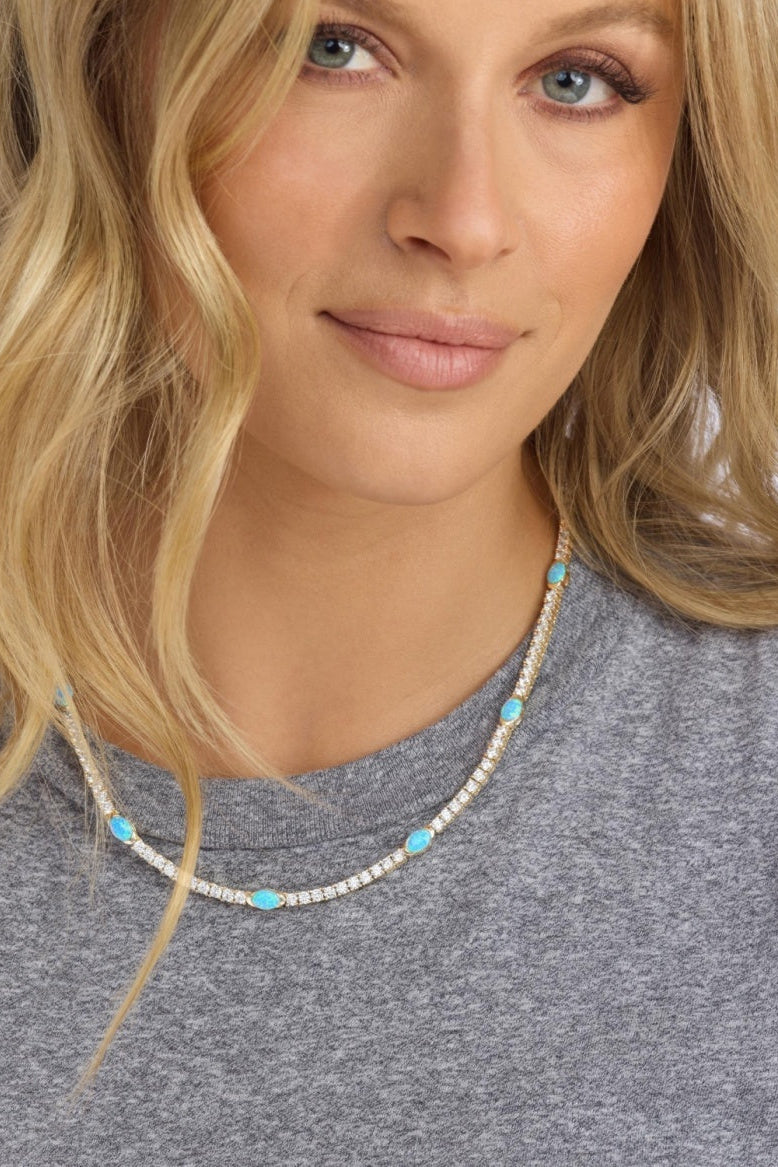 Woman wearing a gold and blue necklace
