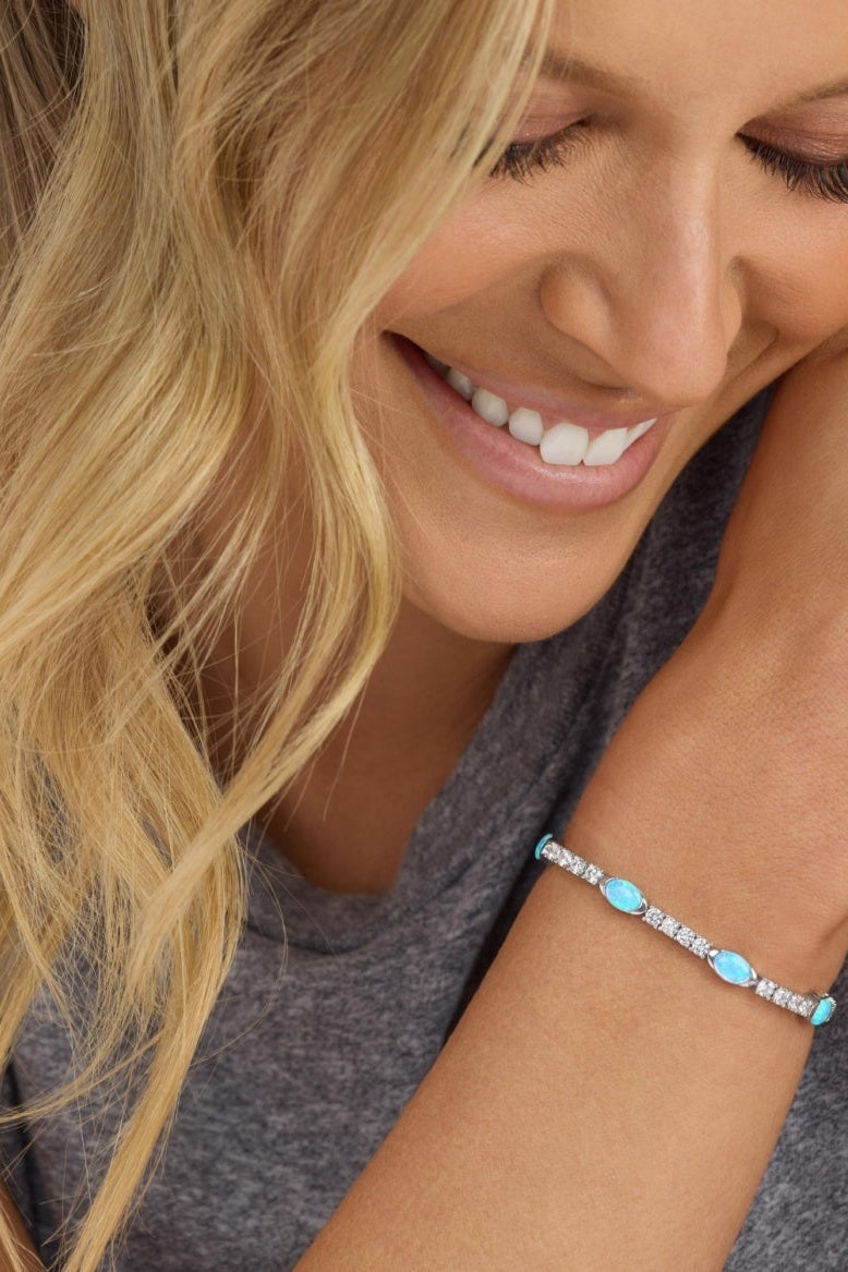 Blue oval-stone tennis bracelet with crystal accents on wrist