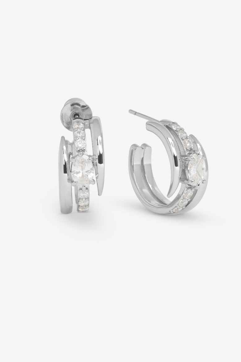 Pair of silver hoop earrings with clear gemstones on a white background