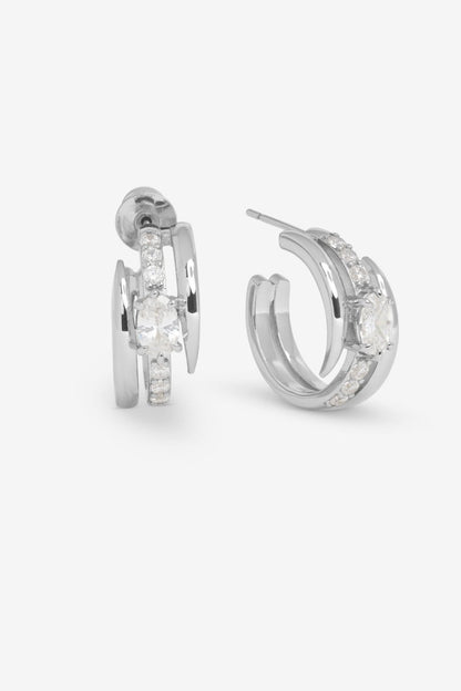 Pair of silver hoop earrings with clear gemstones on a white background
