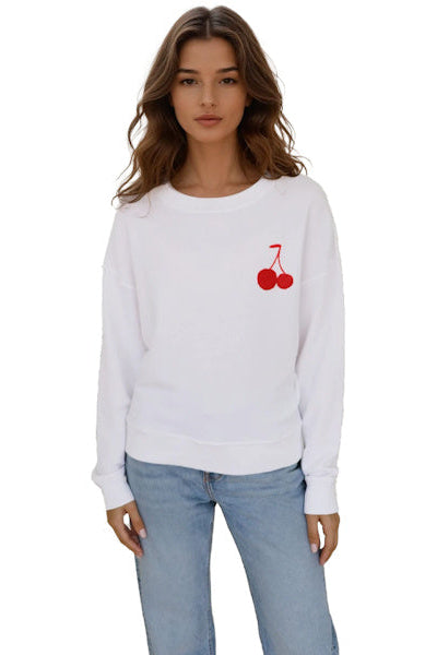 Woman wearing a white sweatshirt with a red cherry design on a white background