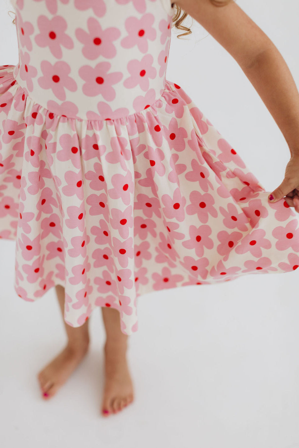 Pink floral twirl dress close-up with gathered waist seam and flared skirt