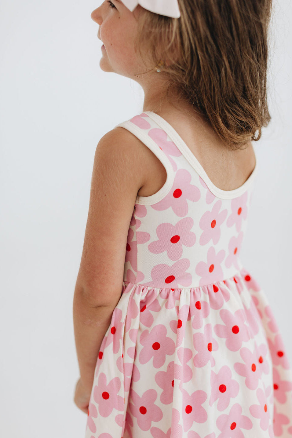 Pink floral twirl dress with sleeveless scoop neck and gathered skirt, side view