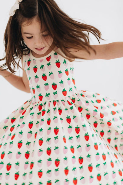 White twirl dress with strawberry and cactus print, sleeveless bodice and gathered skirt