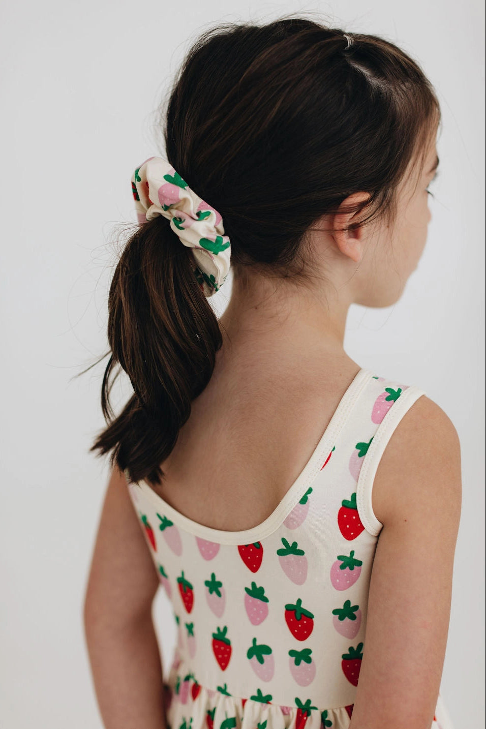 Strawberry and cactus twirl dress back close-up with thin shoulder straps and gathered skirt