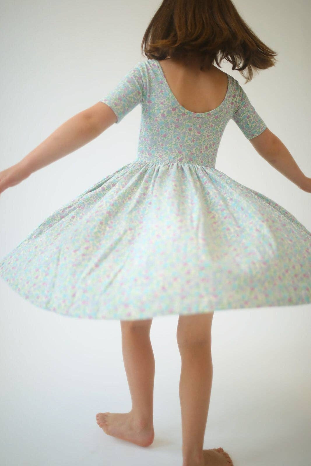 Girls green floral twirl dress, back view, short sleeves and flared skirt