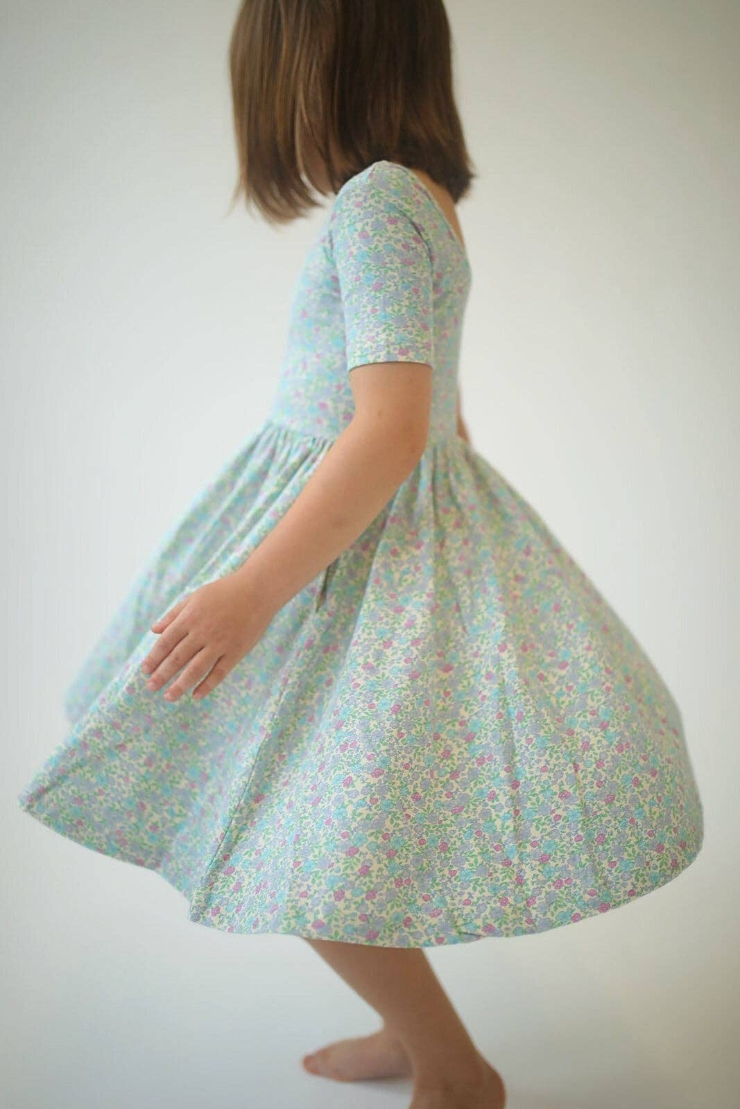 Girls green floral twirl dress, back side view, gathered waist and flare