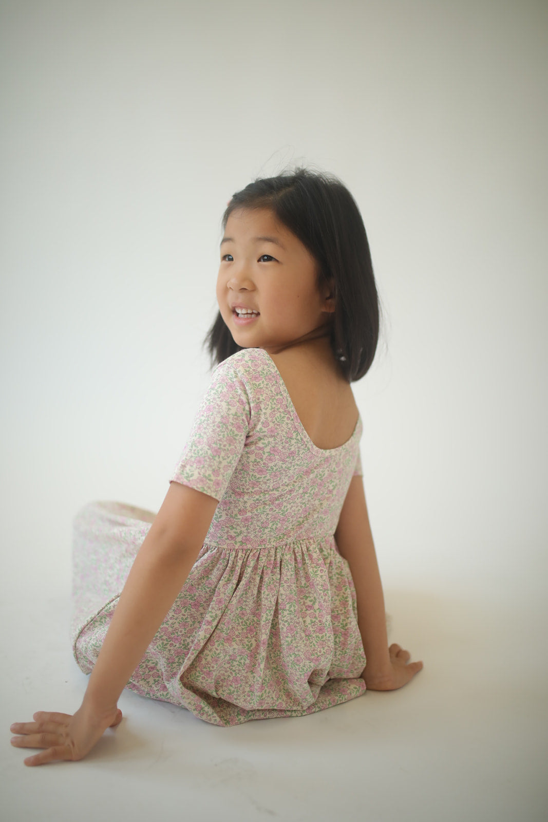 Girls twirl dress in pink speckled floral print, short sleeves, gathered skirt.