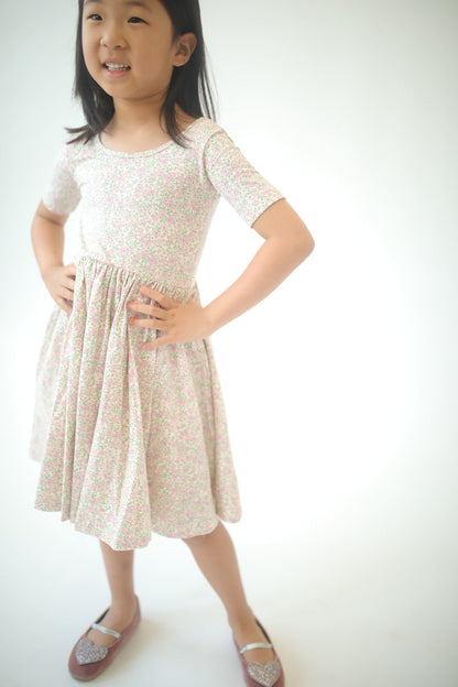 Girls twirl dress in pink speckled floral print, short sleeves, gathered waist skirt.