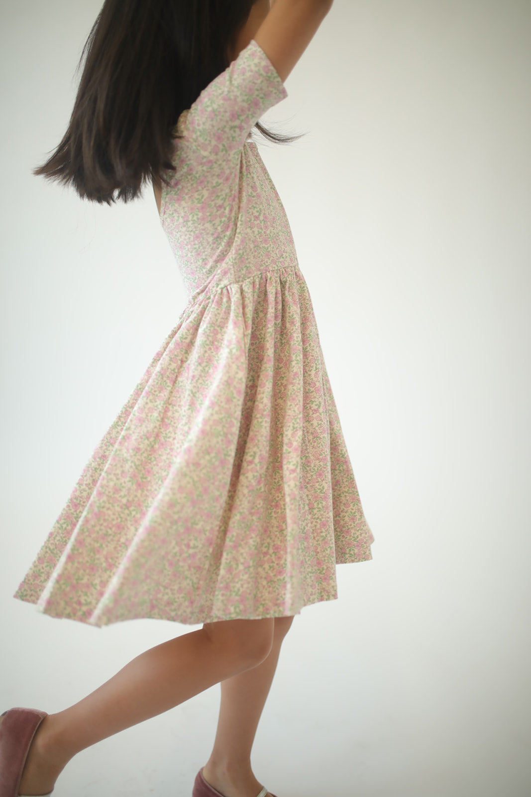 Girls twirl dress in pink speckled floral print, twirly A-line skirt, back view.