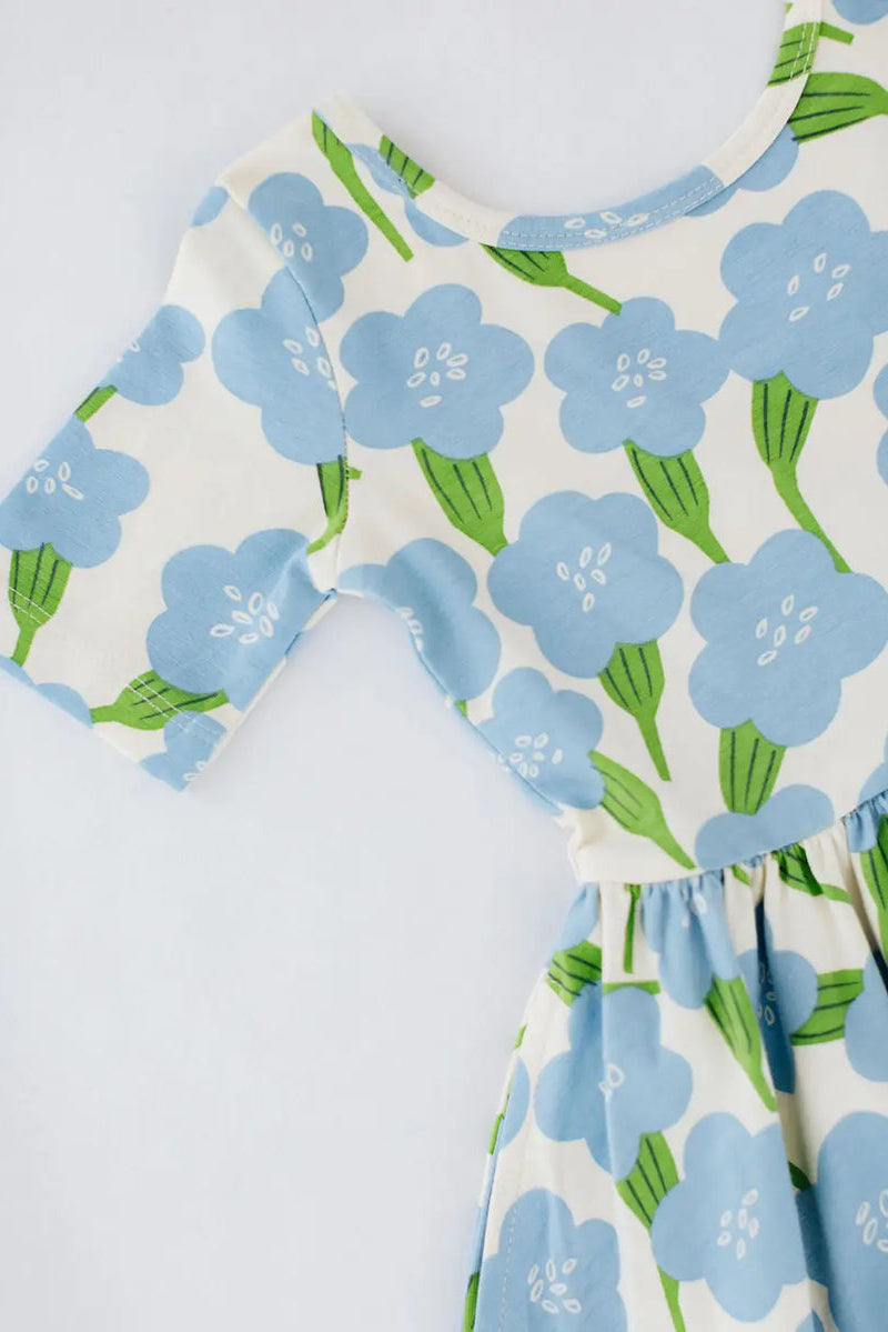 Girls twirl dress bodice close-up in light blue floral print, gathered waist skirt.