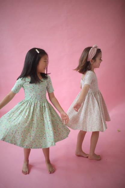 Girls green floral twirl dress, twirly skirt, paired with a light pink dress