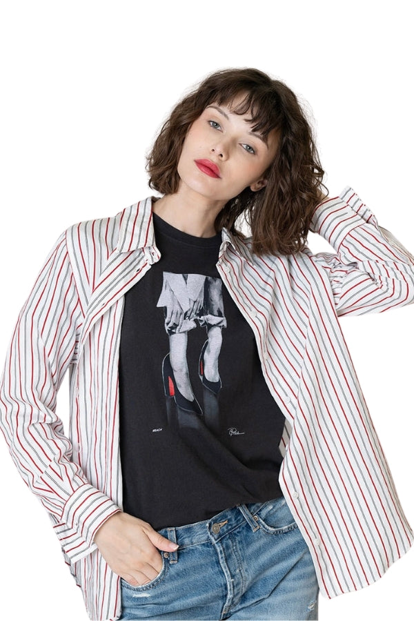 Woman wearing a striped shirt over a graphic t-shirt on a white background