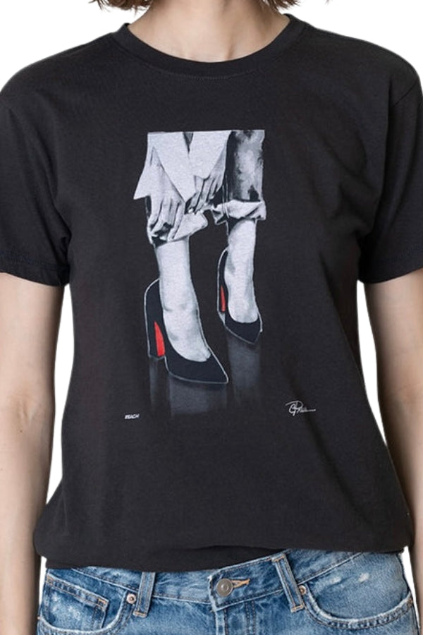 Black t-shirt with graphic design of legs in high heels worn by a person.