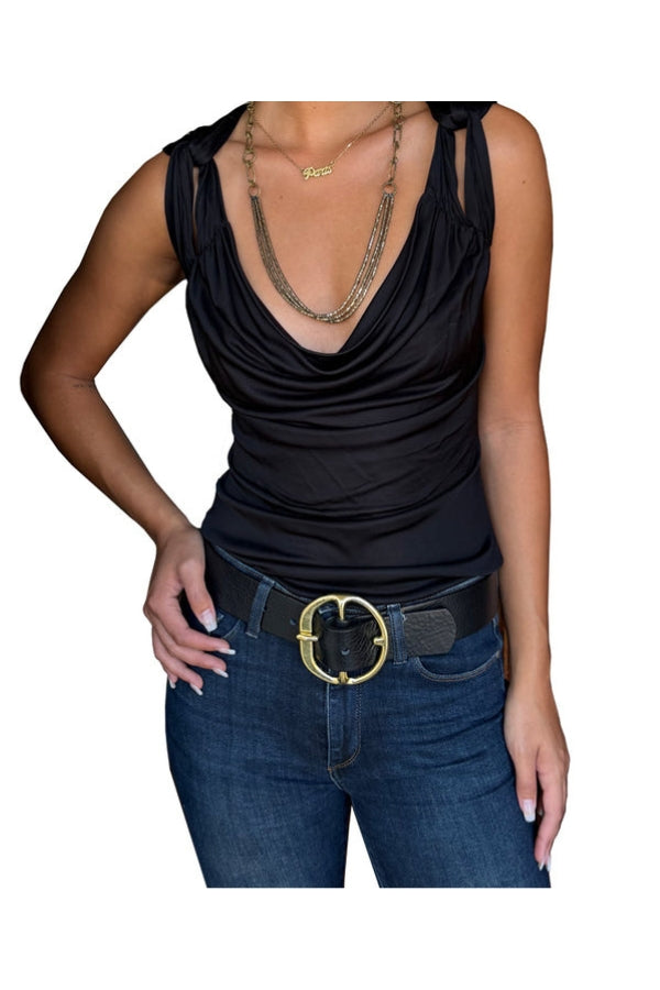 Person wearing a black sleeveless top and blue jeans with a gold belt on a white background