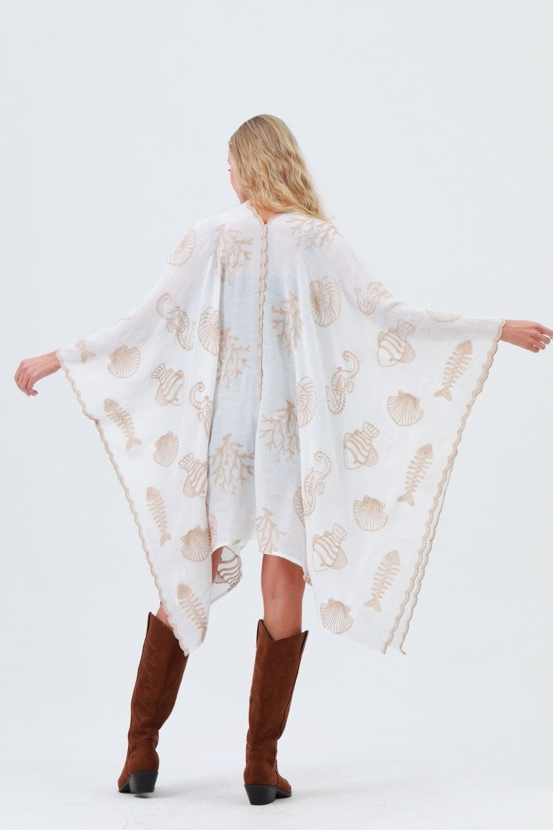 Back view: white kimono with shell and seahorse embroidery, button placket