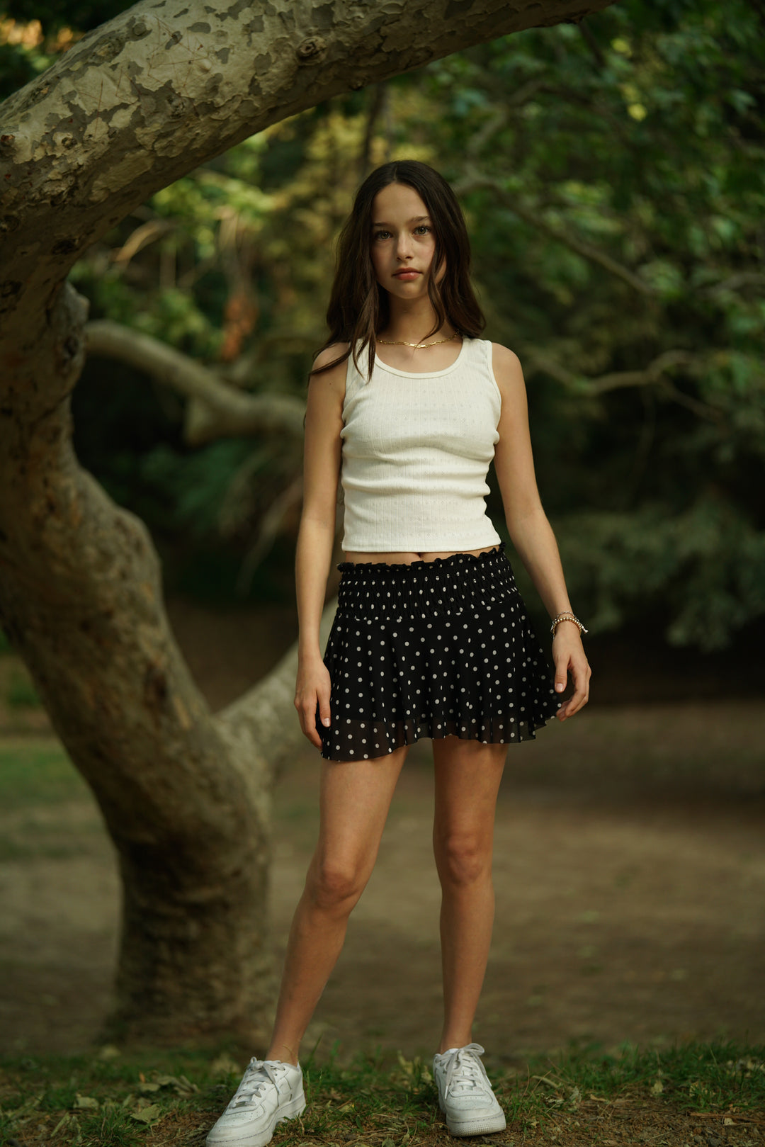 Black mesh skort with white dot pattern, gathered waistband and pleated skirt
