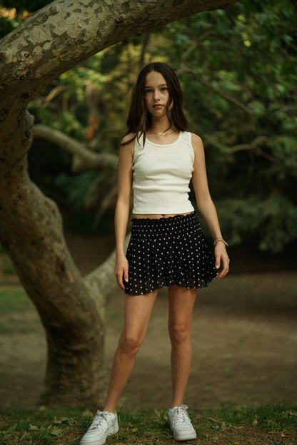 Black mesh skort with white dot pattern, gathered waistband and pleated skirt