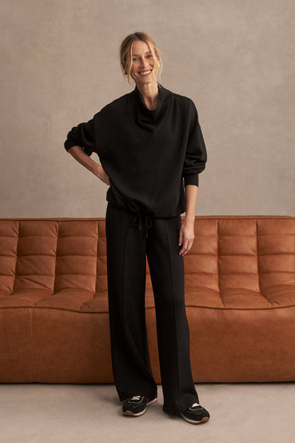 Black wide-leg pants with gathered elastic waist and front tie, roomy fit