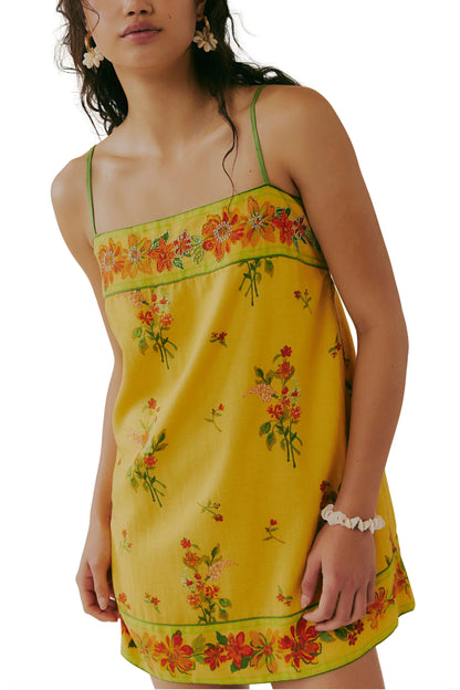 Yellow floral mini dress with green spaghetti straps and ruffled hem