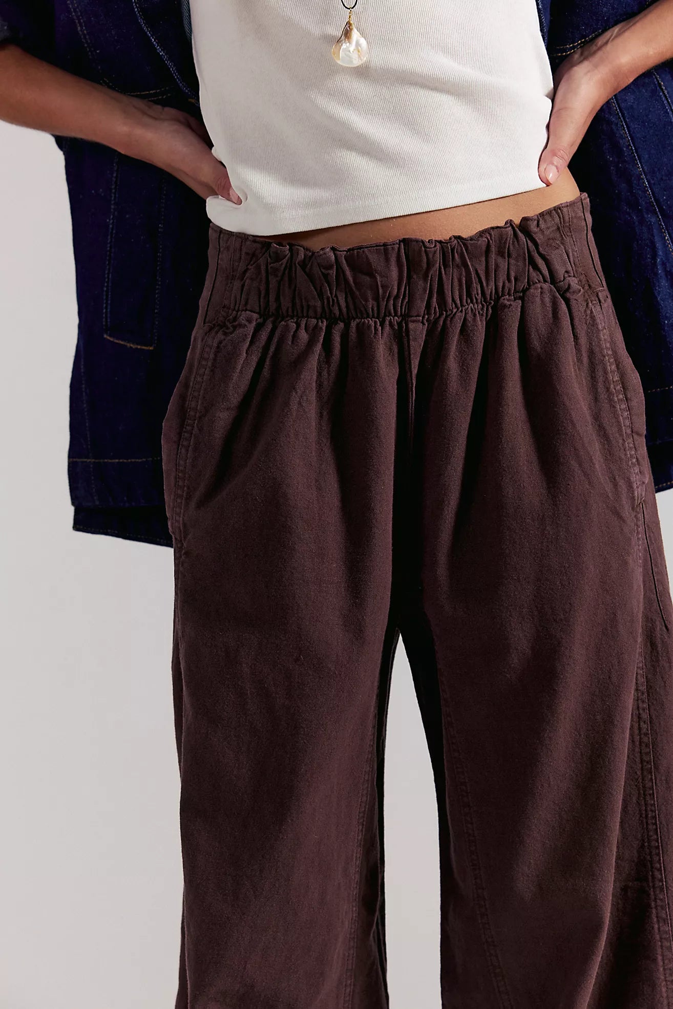 Close-up of dark brown linen pull-on pants: elastic waist with gathered pleats